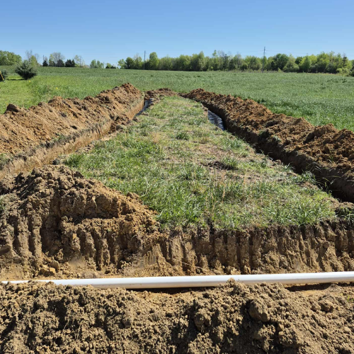 Freshly excavated drain-field trenches during a septic installation