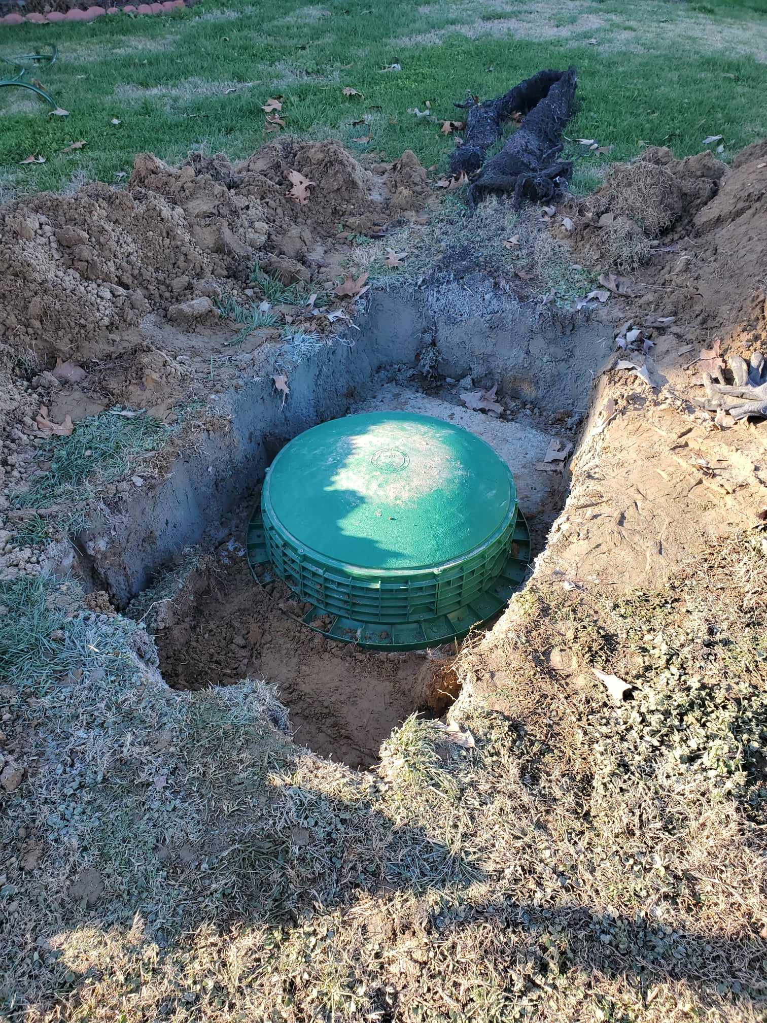 Excavated septic tank access fitted with a green riser